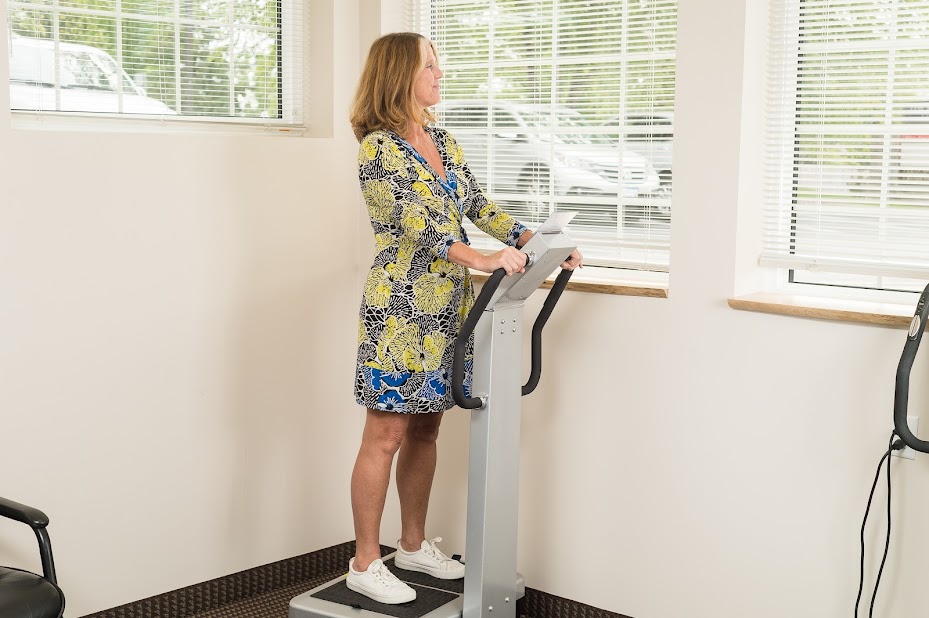 A woman standing on a vibe platform for vagus nerve stimulation.