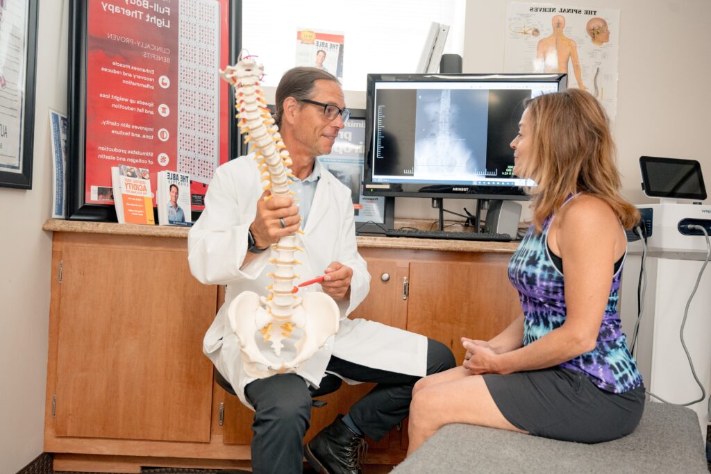 Dr. Brian showing patient spine and explaining chiropractic treatment