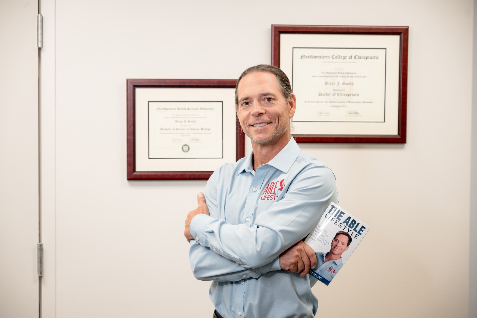 Dr. Brian holding the ABLE Lifestyle book