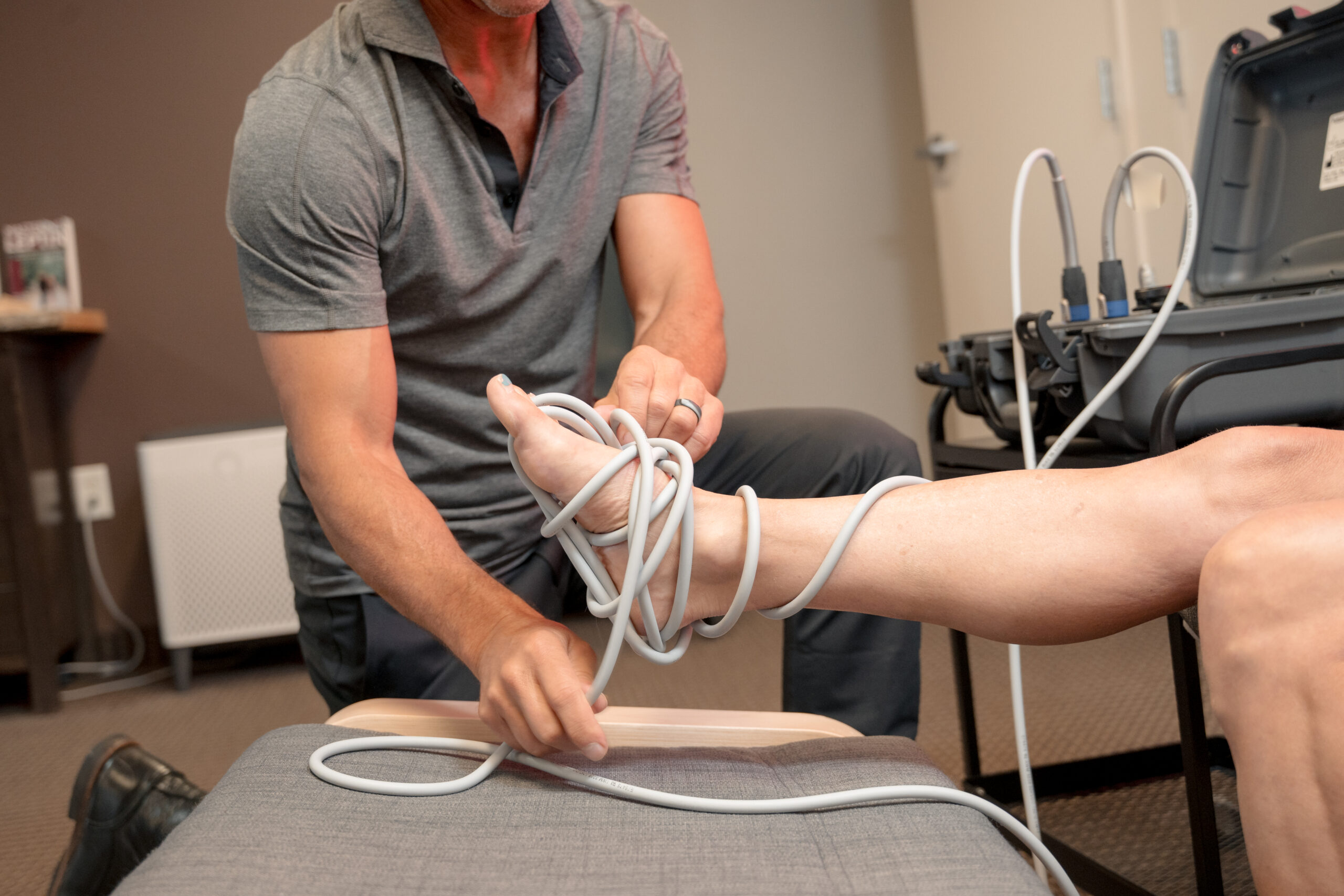 Dr. Brian applies a PEMF treatment to a patient's foot injury.