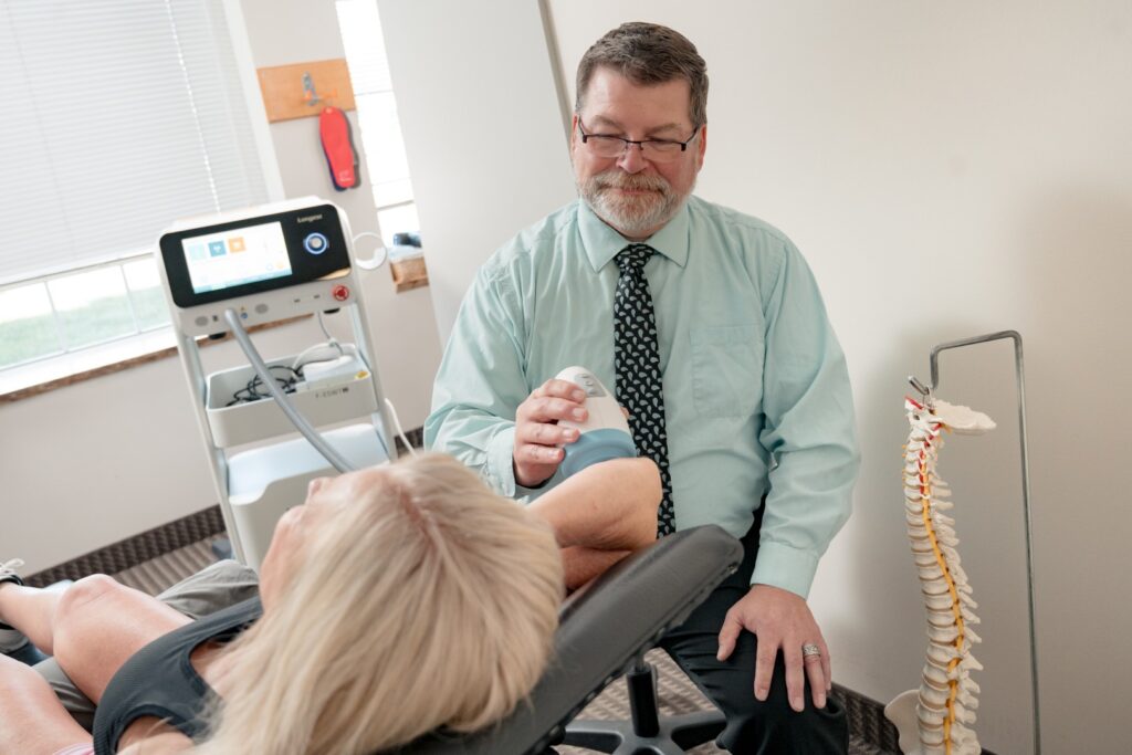 Shockwave therapy device treating a patient's elbow.
